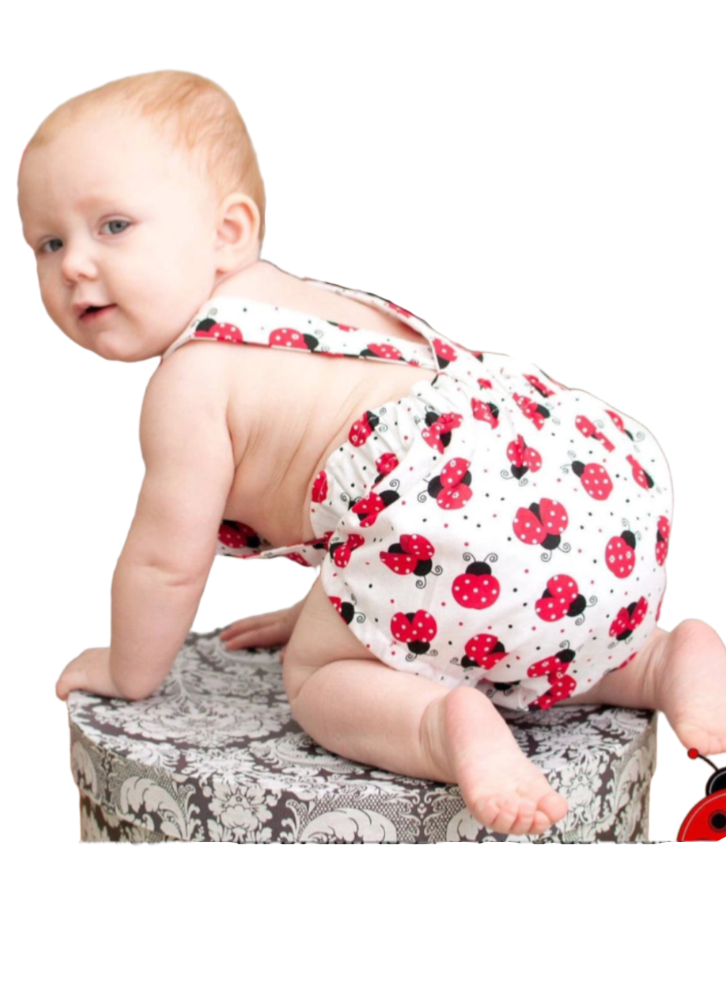 Gender neutral ladybug romper with straps that button at the front.