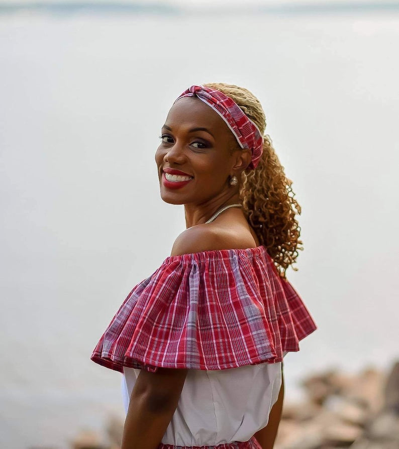 Close up of a Jamaican lady wearing a traditional bandana red plaid print white and bandana print top with a headwrap