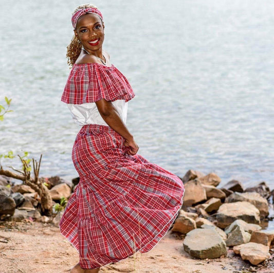 Jamaican lady wearing a traditional bandana red plaid print skirt and white and bandana print top with a headwrap