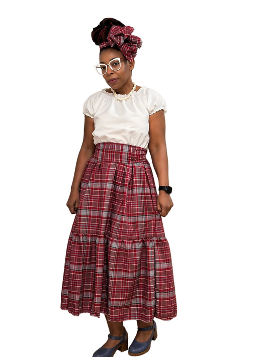 Jamaican white and red,white & blue bandana plaid dress with waist sash and headwrap modeled by the owner of Ackee Tree Clothing with a white background.