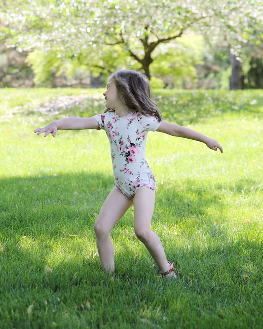 Girl wearing an ivory color floral leotard