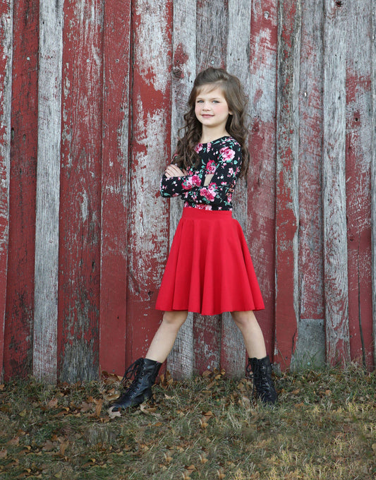 Versatile black floral leotard paired with a red twirly skirt.