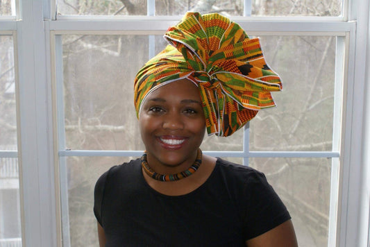 Black woman wearing an African print Kente head wrap for everyday wear.