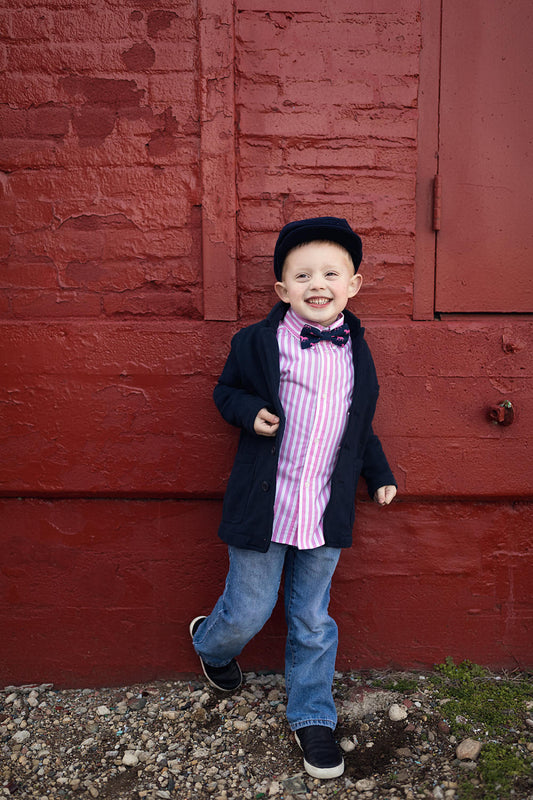 Child wearing a navy bow tie with pink and white Derby horses print
