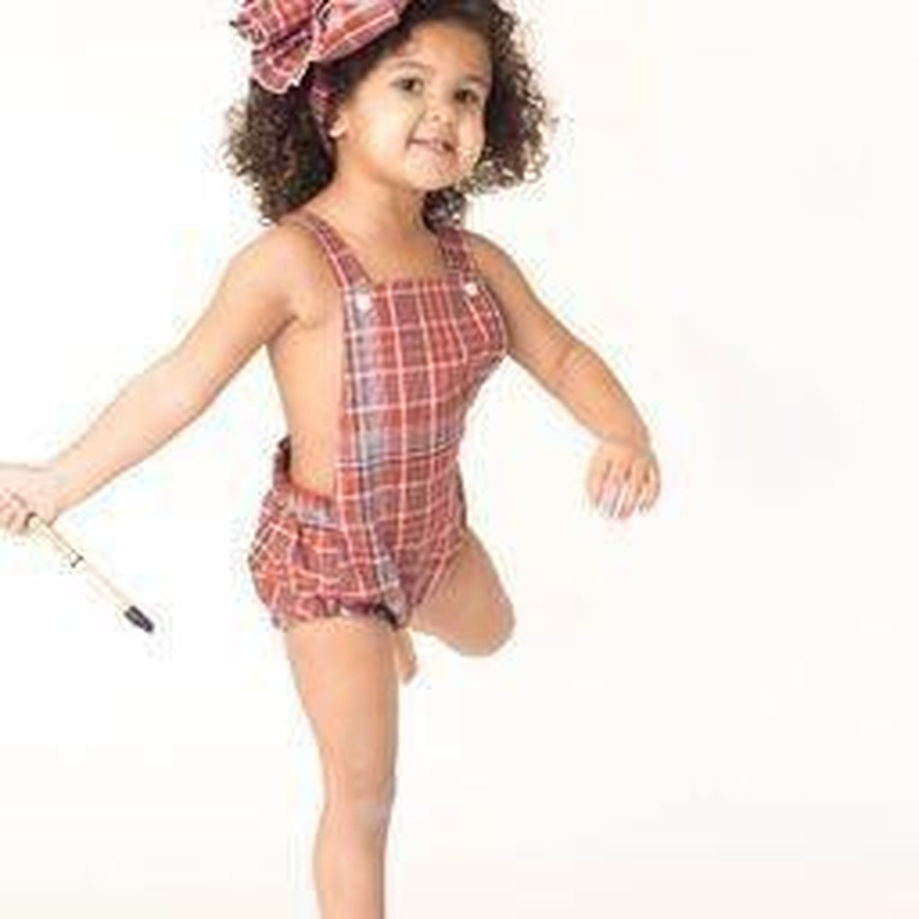 African American girl wearing a Jamaican bandana baby romper and optional headwrap.