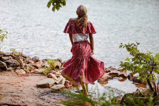 African American woman facing away from the camera wearing a Jamaican bandana skirt and peasant top set.