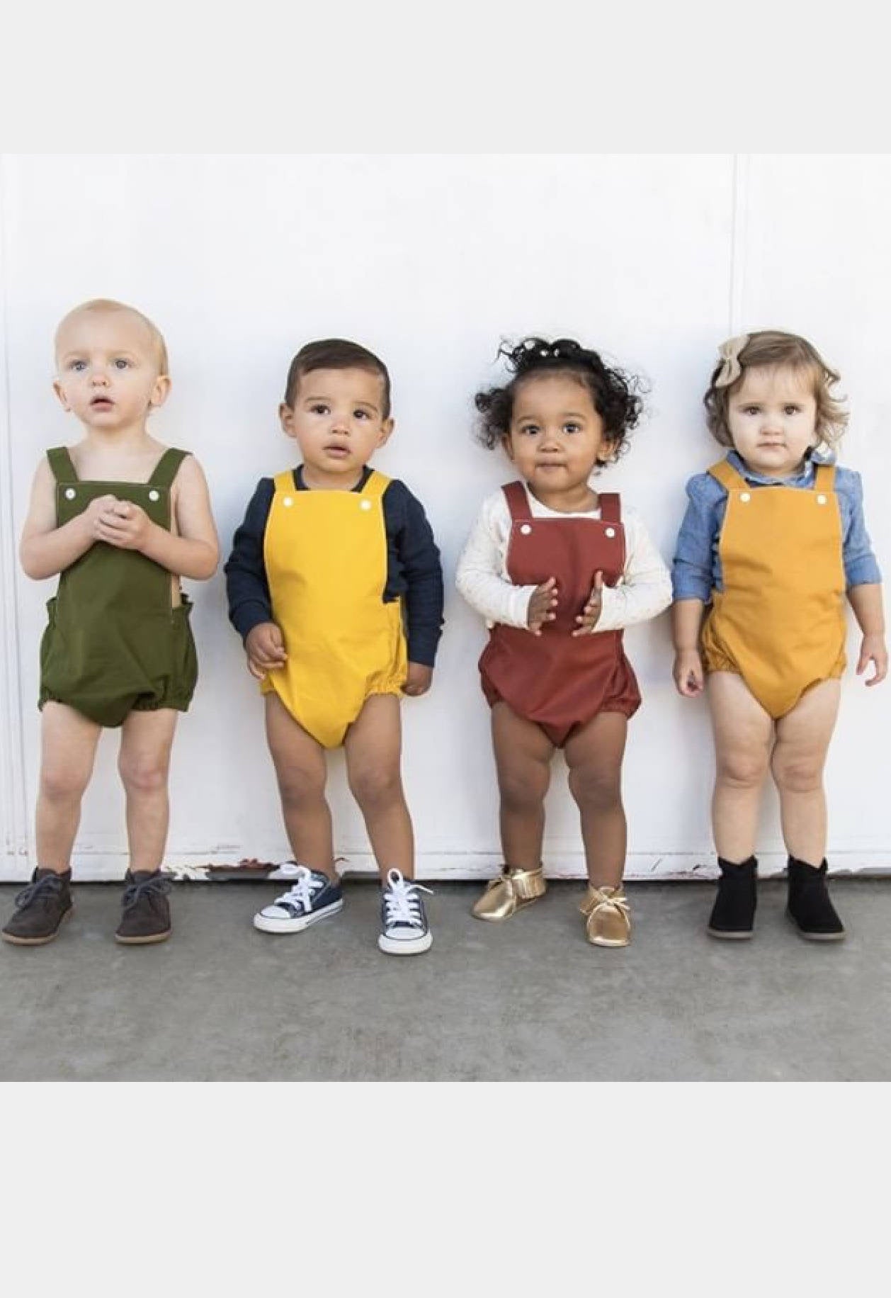 Toddlers in solid color baby boho rompers with snaps at the bib and elasticated legs. 