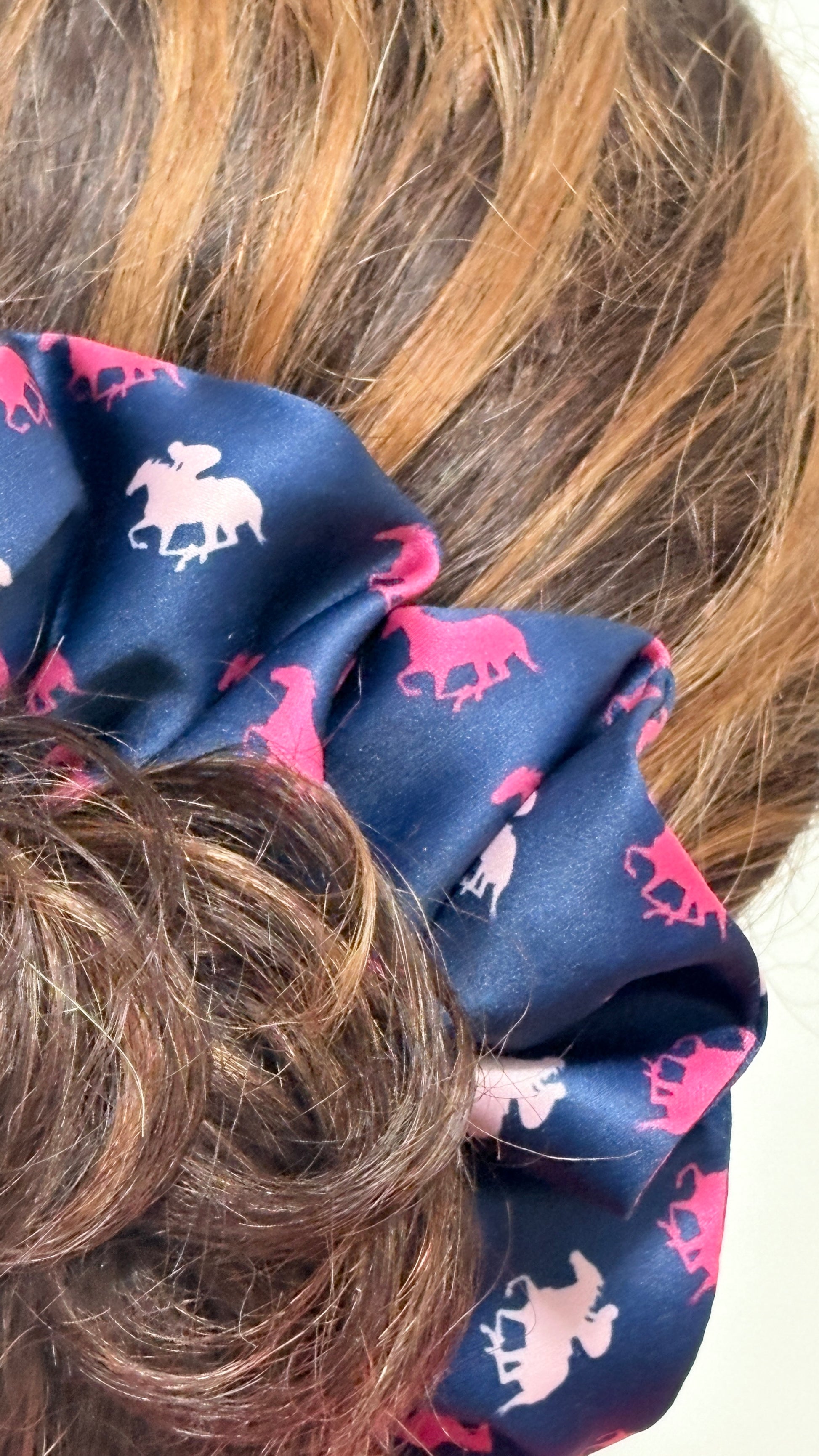 Close up of Navy blue scrunchie with pink horse pattern on brown hair