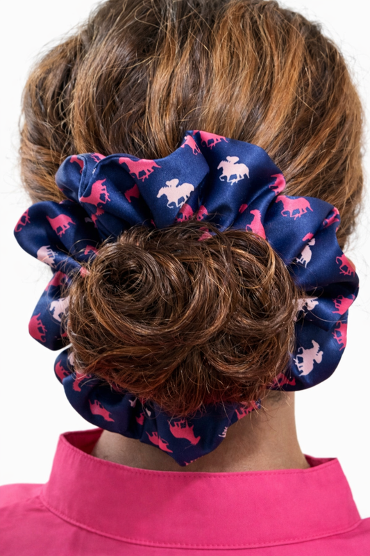 Navy blue scrunchie with pink horse pattern worn by a person with brown hair.